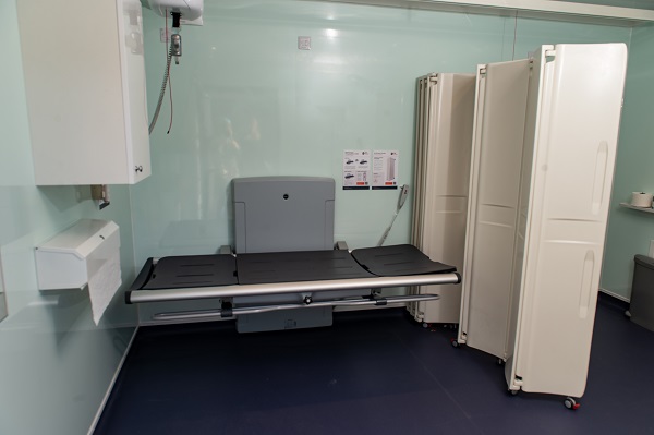 An area of the changing places facility with changing bench and screen shown