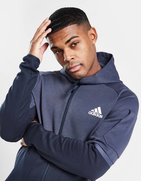 a model wearing a black and grey adidas jacket